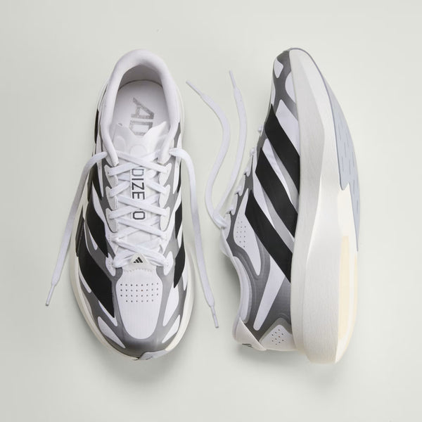 White and black Adidas running shoes on a light gray background