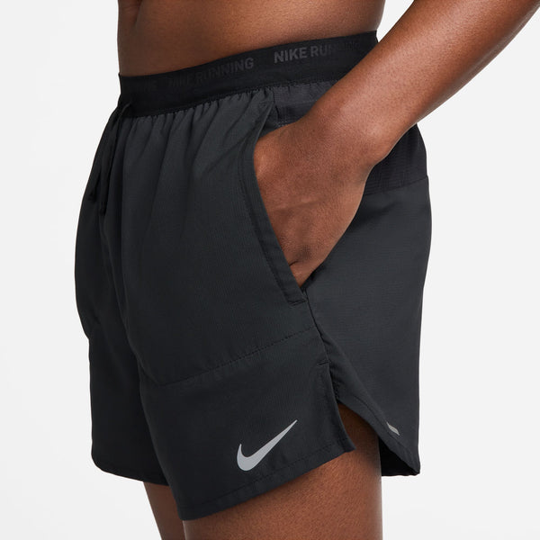 Black Nike running shorts on a person against a white background