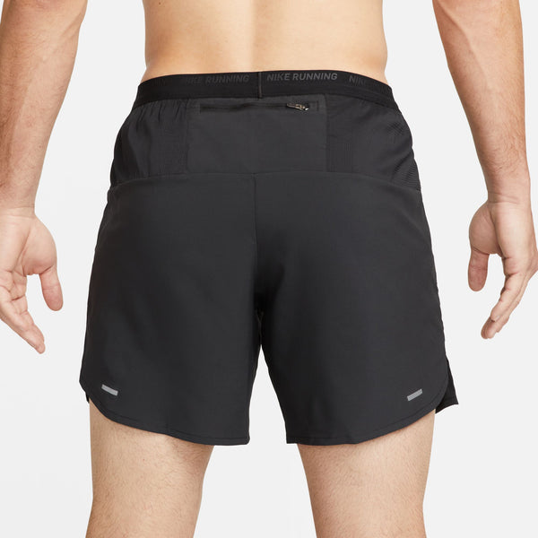 Black Nike running shorts on a person against a light gray background