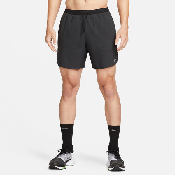 Person wearing black athletic shorts and socks on a white background