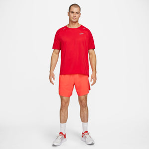 Man wearing a red Nike shirt and shorts on a white background