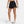 Person wearing black athletic shorts with a brand logo on a white background