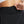 Person adjusting the waistband of black pants.