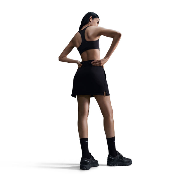 Woman wearing a black athletic outfit on a white background