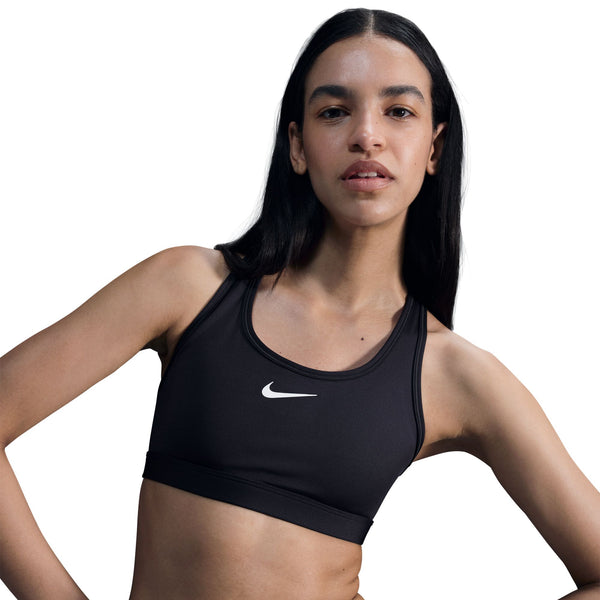Woman wearing a black Nike sports bra on a white background