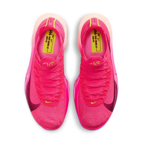 Pink running shoes with yellow footbeds accents on a white background