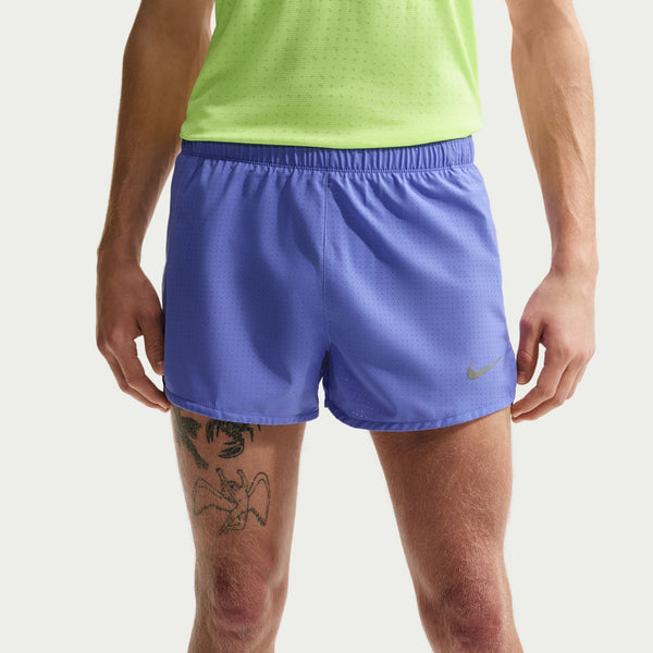Person wearing blue athletic shorts with a Nike logo on a light gray background