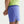 Person wearing blue shorts with a brand logo on a light gray background