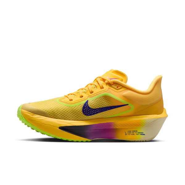 Medial side of a yellow running shoe with a colorful sole on a white background.