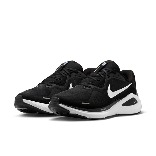 Black Nike training shoes with white accents on a white background.