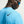Person wearing a blue Nike shirt with a black logo on a neutral background
