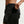 Person wearing black athletic shorts with a pocket on a light gray background
