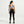 Person wearing a light blue sports bra and black leggings on a white background