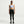 Woman wearing a light blue sports bra and black leggings on a white background