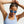 Person wearing a light blue tank top and white sunglasses with blue lenses on a white background