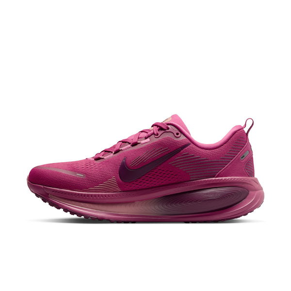 The medial side of a very dark pink running shoe with Nike logo on a white background.