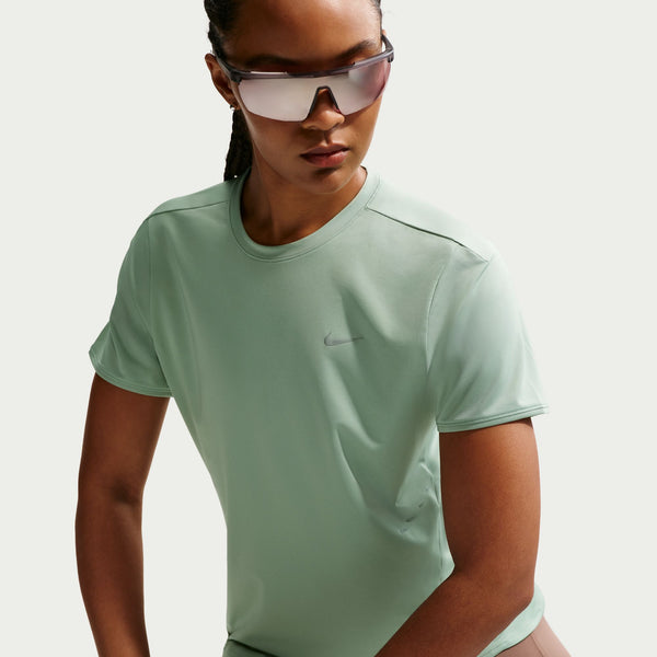 Person wearing a light green Nike t-shirt on a plain background