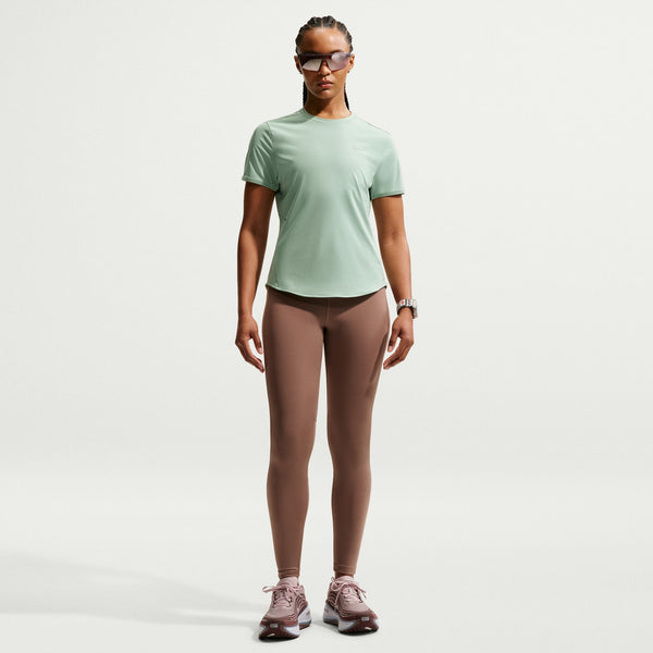 Person wearing a light green t-shirt and brown leggings on a white background