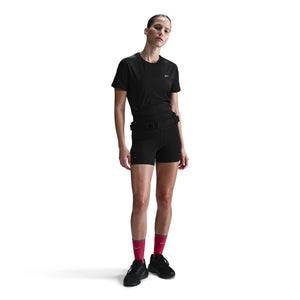 Person wearing a black outfit with a belt and pink socks on a white background