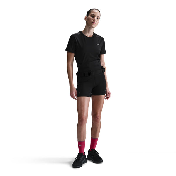 Person wearing a black outfit with a belt and pink socks on a white background