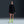 Person wearing a black athletic outfit with neon green socks and shoes on a dark background