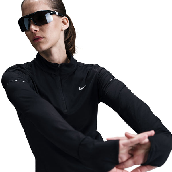 Person wearing a black Nike athletic jacket and sunglasses on a white background