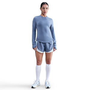 Woman wearing a blue athletic outfit with white shorts on a white background