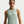 Woman wearing a light green Nike tank top against a plain background