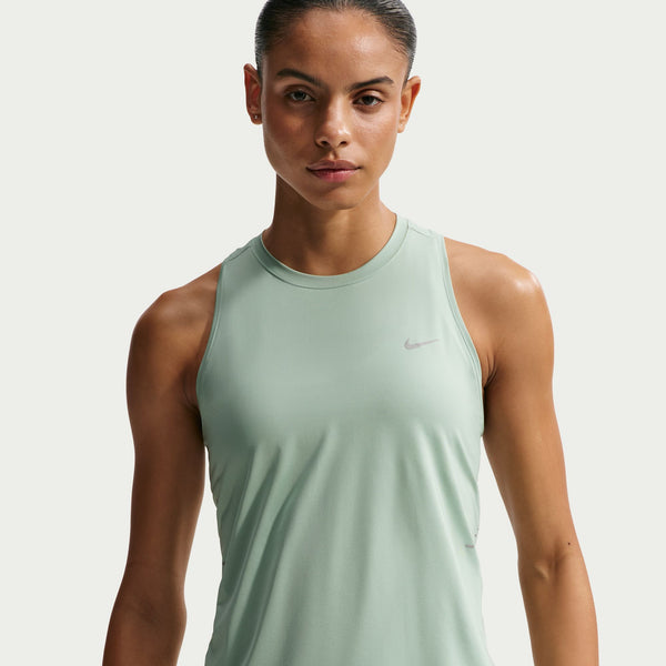 Woman wearing a light green Nike tank top against a plain background
