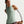 Woman wearing a green athletic tank top with a Nike logo on a white background