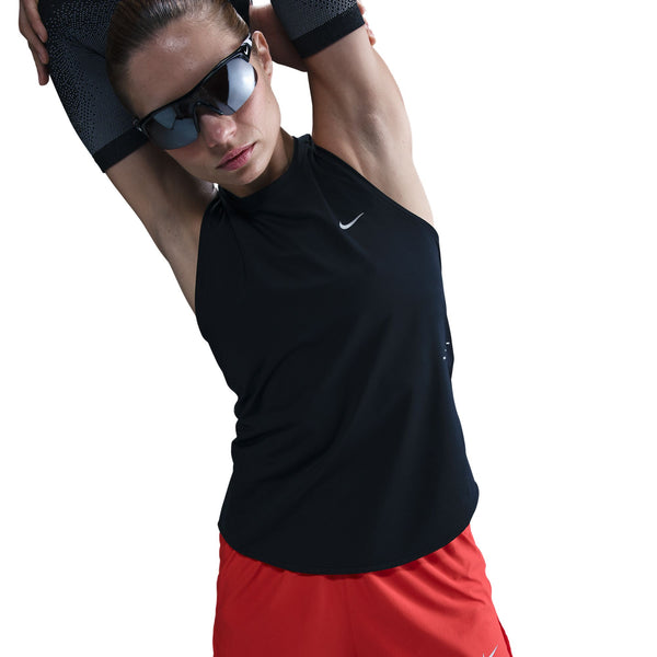 Person wearing a black sleeveless top and red shorts with a white background