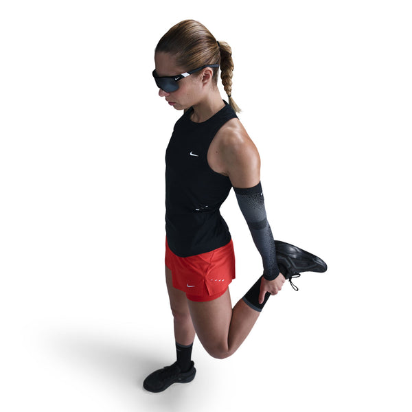 Woman in athletic wear with a Nike shirt and red shorts on a white background