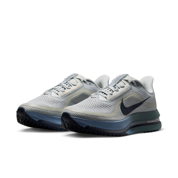Pair of gray athletic shoes with a Nike logo on a white background