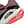 Close-up of a running shoe with 'ZoomX' technology, featuring red and white sole and maroon side panel.