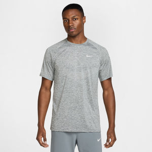 Man wearing a gray Nike t-shirt and pants on a white background