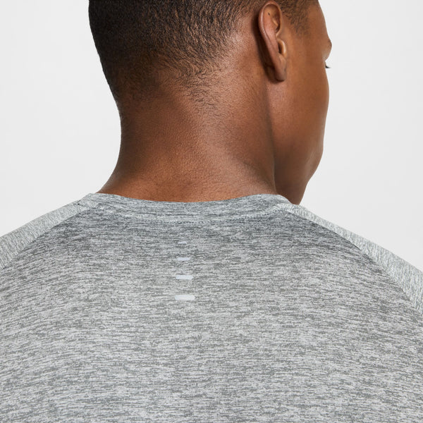 Person wearing a gray athletic shirt on a light gray background