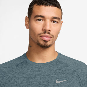 Man wearing a blue Nike shirt against a light gray background