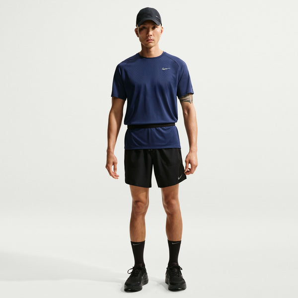 Person wearing a blue Nike t-shirt and black shorts on a white background