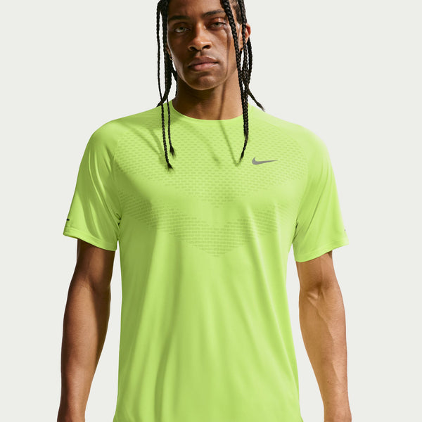 Person wearing a bright green Nike t-shirt on a light gray background