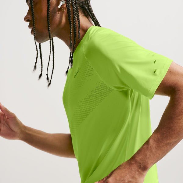 Person wearing a bright green athletic shirt on a plain background