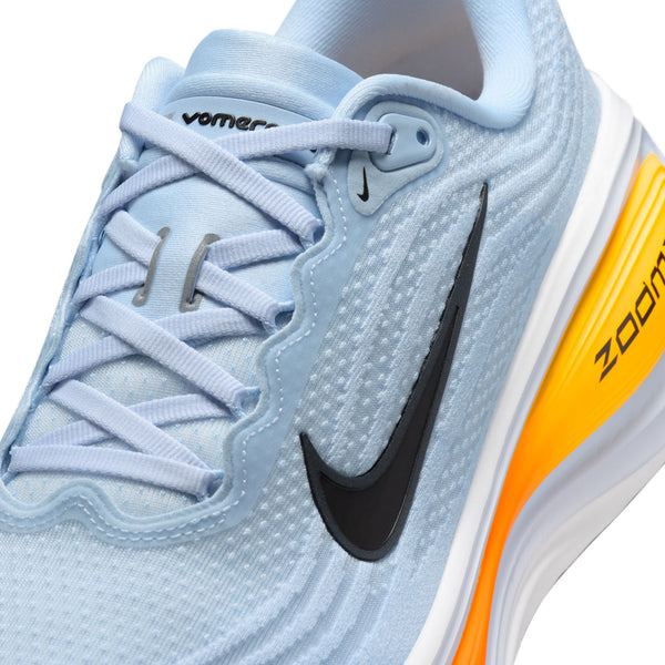 Light blue running shoe with orange sole and black Nike logo on a white background