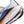 Close-up of a running shoe with white, blue, orange, and black design on a white background