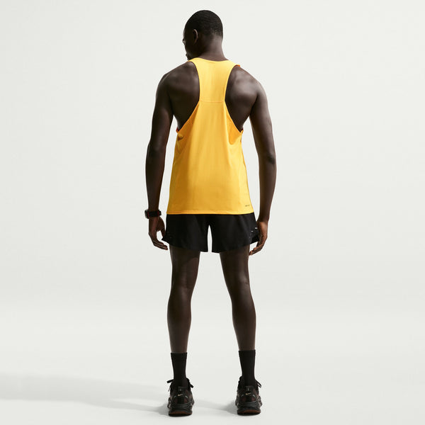 Person wearing a yellow tank top and black shorts on a white background