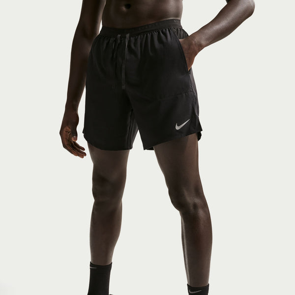 Person wearing black athletic shorts with a Nike logo on a light gray background
