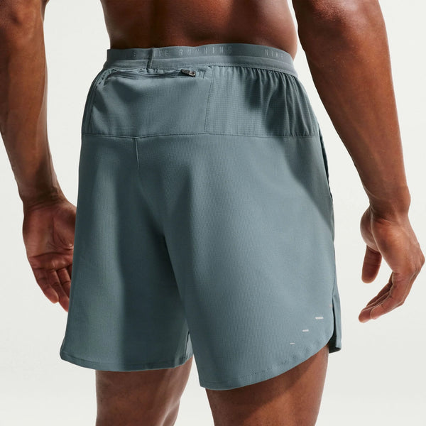 Person wearing a pair of gray athletic shorts on a plain background