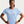 A woman wearing a light blue Nike athletic short-sleeve shirt, standing with hands on hips against a light gray studio background.
