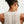 Person wearing a beige tank top with a brand logo on a white background