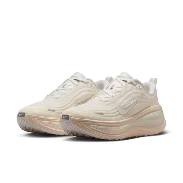 Pair of beige and white running shoes on a white background.