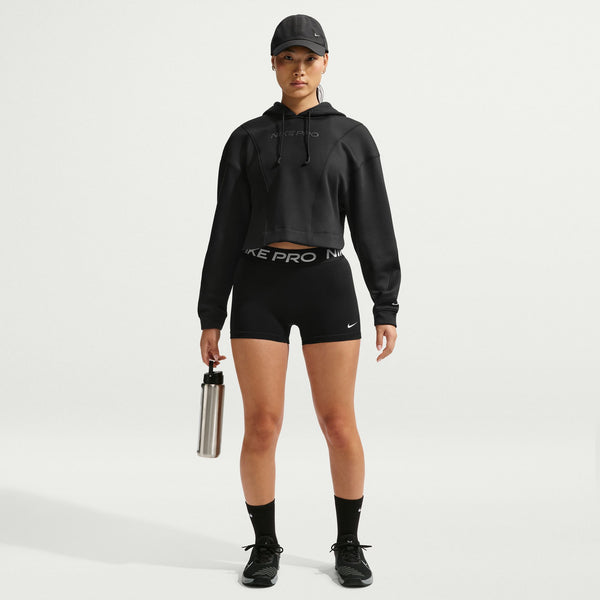 Person wearing a black Nike Pro hoodie and shorts on a light gray background