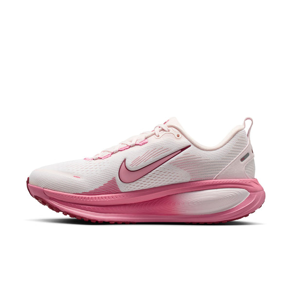 Medial side of a women's running shes with a mostly white upper and a pink colored midsole.